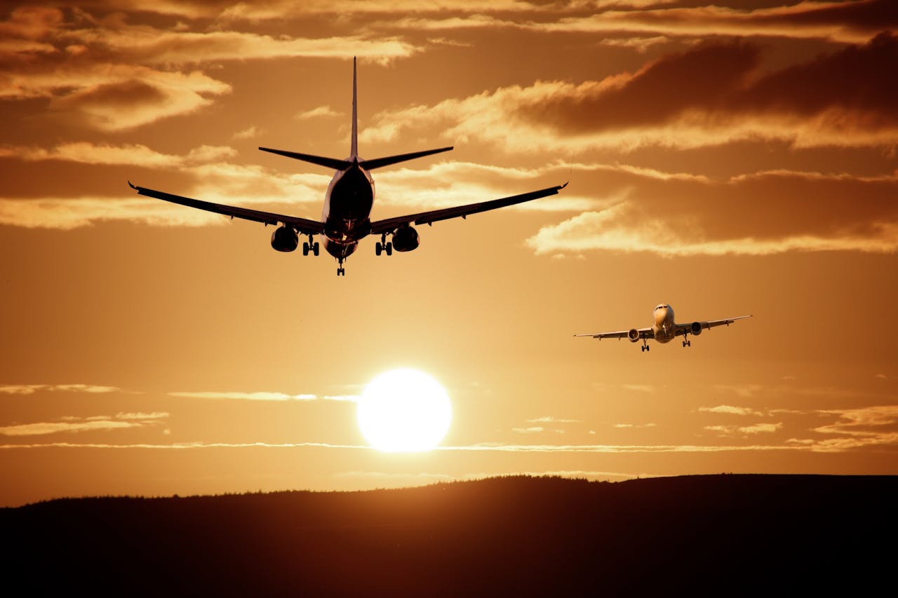 social-feed-img-01 Silhouetted airplanes landing against a dramatic sunset sky, capturing the essence of flight.